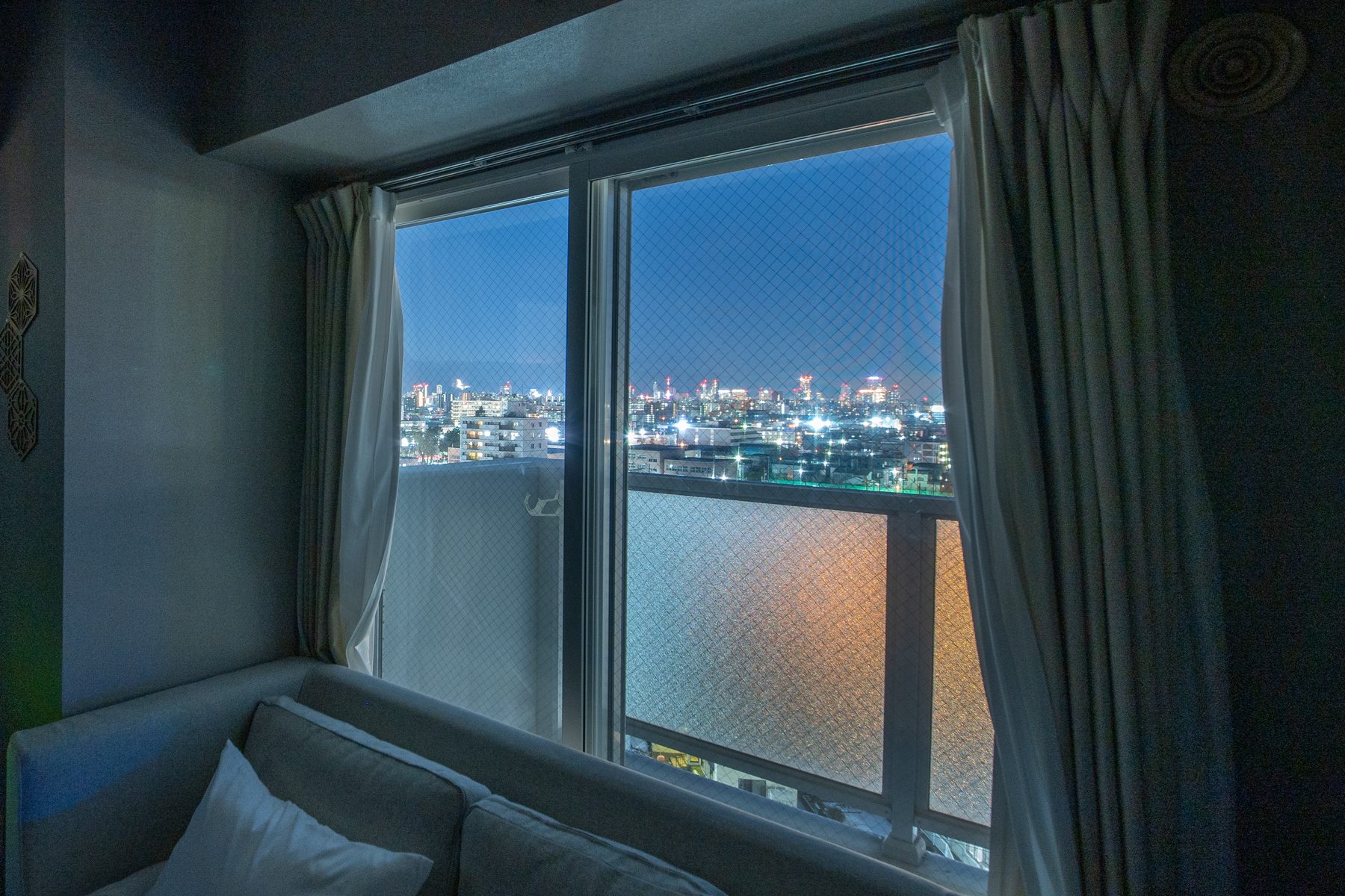 1001号室の窓辺。ソファ越しに札幌の夜景が見える